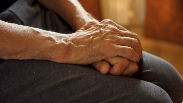 istock The older man's hands are on his knees, waiting. 1572312857