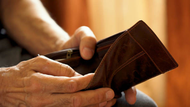 istock An elderly man's hands, covered with knotted veins, search for coins in his wallet 1572312867
