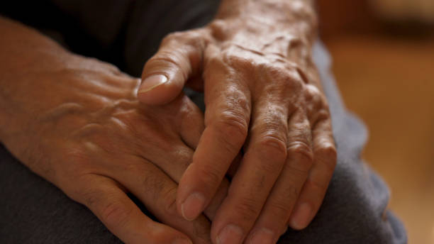 istock The older man's hands are on his knees, waiting. 1572312880