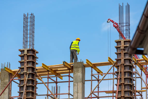 istock A male construction worker stands on reinforced concrete beams at a height. 1572337726