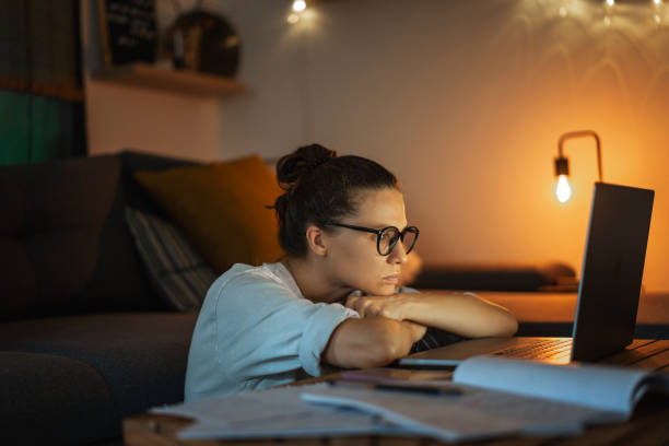 istock Tired depressed young woman working at home at night on a project using a laptop. Problems with long hours workaholism 1572337737