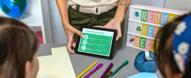 istock Teacher showing tablet with tips to be more ecological for students in environmental classroom 1572340457