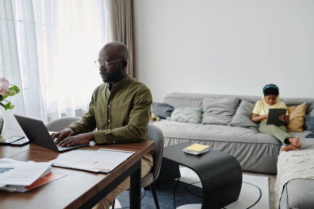 istock Dad working on laptop at home 1572361234