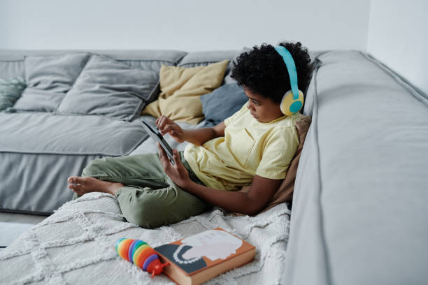 istock Little boy playing on tablet pc at home 1572361240