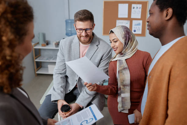 istock Two happy young colleagues looking at financial document at meeting 1572377412