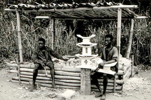 Dodowa, Greater Accra, Ghana - March 1959: Craftsmen carving traditional wooden stools in Dodowa, Greater Accra, Ghana