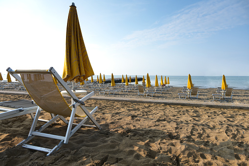 Empty beach morning atmosphere no people sandy beach deckchair sea sunshade against blue sky calm water concept no guests rest vacation lonely island decline tourism sales decrease overnight stays