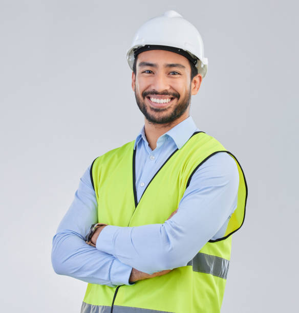 Ouvrier du bâtiment, ingénieur et portrait de studio d’homme heureux en gilet et casque pour la sécurité sur fond blanc. Smile, entrepreneur ou architecte en planification ou rénovation, chef de projet en Inde. - Photo