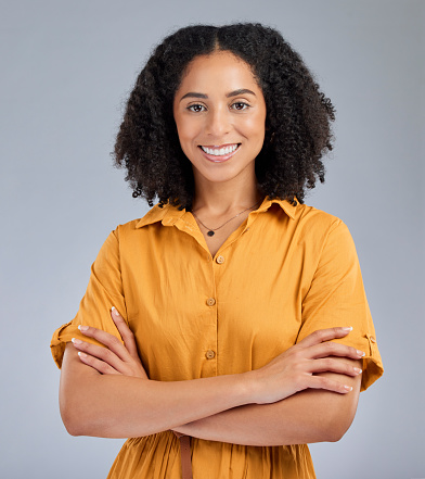 Happy, pride and portrait of a woman with arms crossed isolated on a studio background. Smile, proud and headshot of a corporate employee with confidence, success and happiness on a backdrop