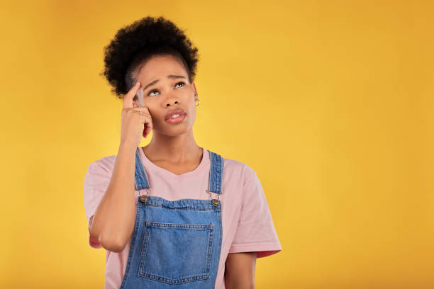 istock Question, thinking and woman confused, decision and choice against a yellow studio background. Female person, why and model anxious, stress and emoji with doubt, ideas and problem solving with memory 1572443344