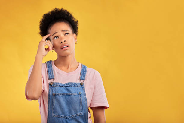 istock Mockup, thinking and woman confused, opportunity and solution against a yellow studio background. Female person, ideas and model with questions, decision and problem solving with doubt and choice 1572443346