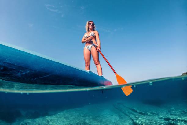 istock Woman paddling on a stand-up paddleboard 1572447553