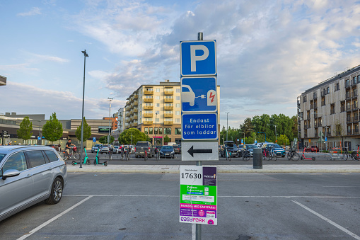 Sweden. Uppsala. 07.26.2023. Close up view of parking sign for charging electric vehicles in parking lot near mall.