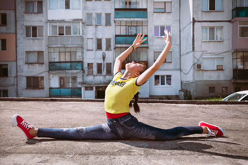 Teenage girl exercising outside early in the morning. Stretching. Active and healthy lifestyle.