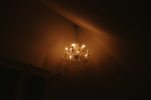 A chandelier lamp lighting a dark room