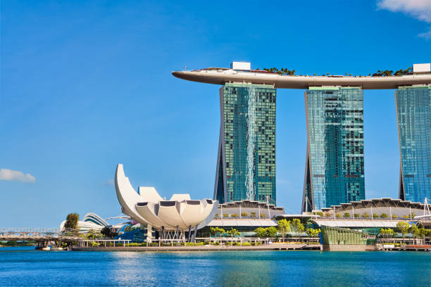 культовый вид на marina bay sands, торговый центр shoppes, музей artscience, мост хеликс в бухте марина в солнечный день. знаменитые достопримечательности г - artscience museum стоковые фото и изображения