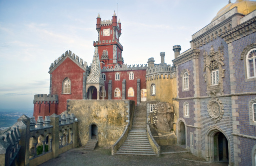 The Pena National Palace is a Romanticist palace in São Pedro de Penaferrim, municipality of Sintra, Portugal. The palace stands on the top of a hill above the town of Sintra, and on a clear day it can be easily seen from Lisbon and much of its metropolitan area. It is a national monument and constitutes one of the major expressions of 19th century Romanticism in the world. The palace dates from middle-age times, is a UNESCO World Heritage Site and one of the Seven Wonders of Portugal.