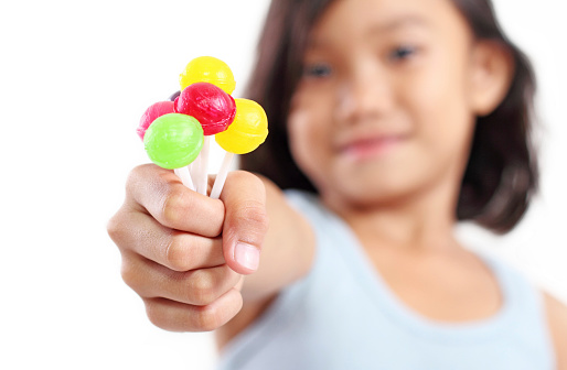 Young girl showing a sweet and colorful lollipops.