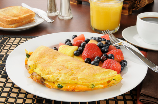 A Western Omelet with fresh fruit and berries