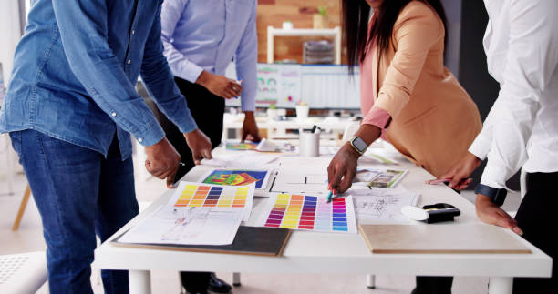 istock Designer Group At Desk Discussing Custom House 1572512882