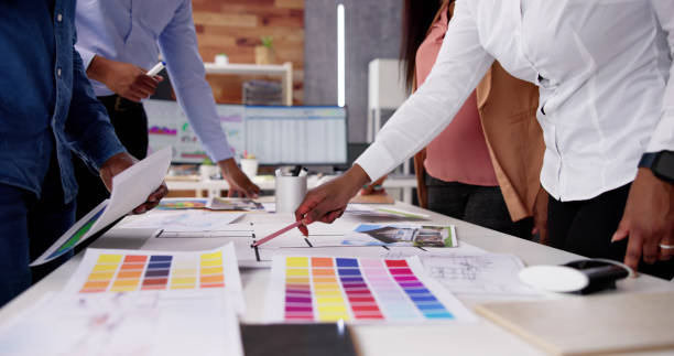 istock Designer Group At Desk Discussing Custom House 1572512884