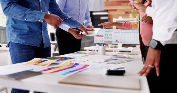 istock Designer Group At Desk Discussing Custom House 1572512885