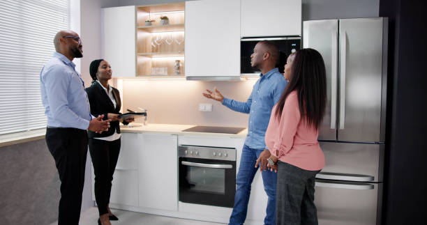 istock Young Woman Checking Kitchen Cabinet During Meeting 1572514009