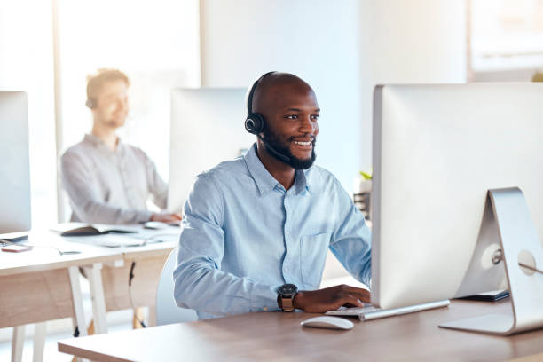 istock Call center, computer and online with black man in office for customer service, technical support and advice. Technology, contact us and communication with employee operator in help desk agency 1572519905