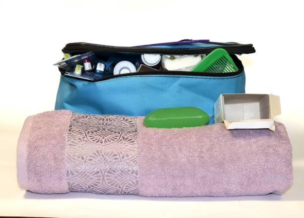 istock Blue bag filled with hygiene items: soap, toothpaste, toothbrushes, combs, towel. 1572520455
