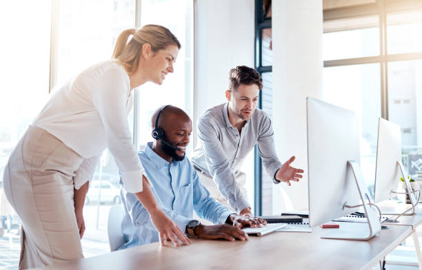 istock Call center team, group of people and help at computer, support in training or collaboration in customer service. Contact us, CRM and coworking with teaching and learning, coaching and communication 1572521502