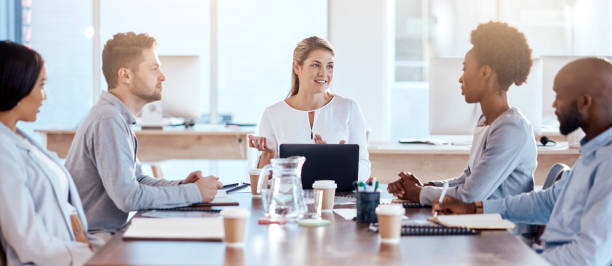 istock Business people, coaching and meeting in teamwork for planning, strategy or collaboration at office. Corporate woman in leadership talking to staff in team brainstorming or project idea at workplace 1572521518