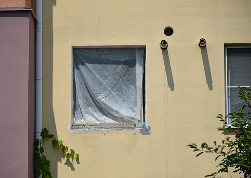 a window without a frame is covered with cellophane film to protect it from moisture and dust during the renovation of the apartment. opaque film protects from prying eyes