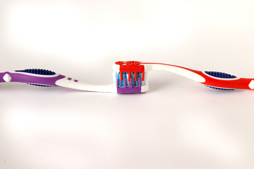 Two new toothbrushes connected with bristles.