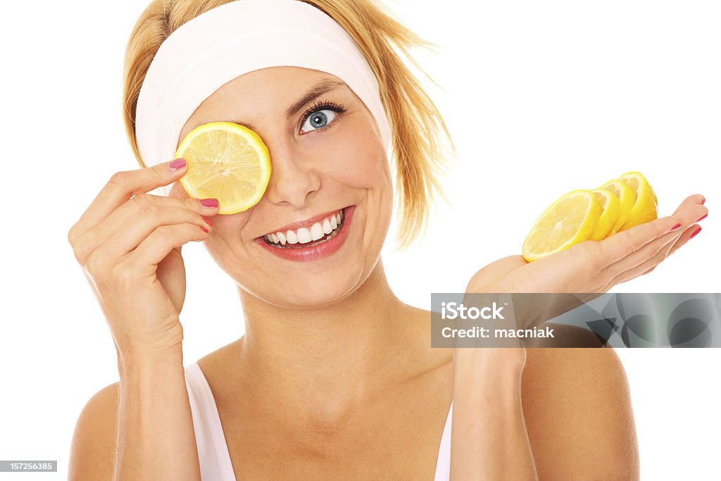 Lemon fun A portrait of a young beautiful woman with lemon over white background Adult Stock Photo