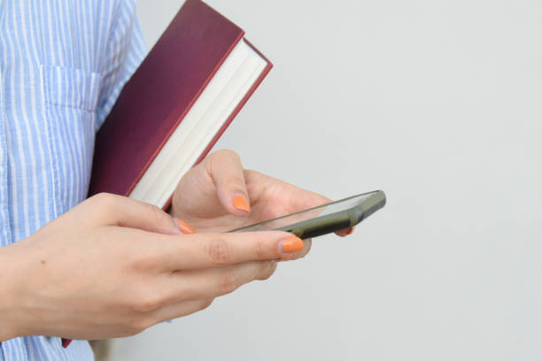 Young woman holding book in her hands, with space for text.