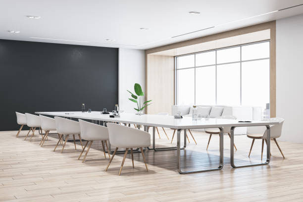 istock Perspective view of modern empty conference room with white office desk and chairs, black wall, wooden floor, and window with city view. 3D Rendering 1572583307