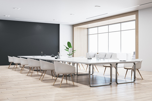 Perspective view of modern empty conference room with white office desk and chairs, black wall, wooden floor, and window with city view. 3D Rendering