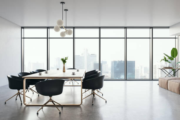 istock Side view of modern luxury meeting room interior with office desk and chairs, panoramic window, white wall and concrete floor. 3D Rendering 1572588073