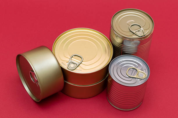 istock Unopened Tin Cans with Blank Edges on Red Background 1572602974