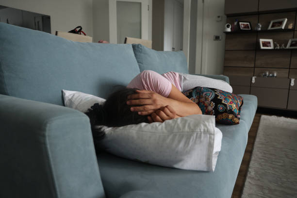 istock Depressed woman lying on sofa 1572626904