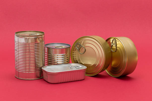 istock Unopened Tin Cans with Blank Edges on Red Background 1572647675