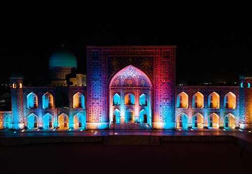 Samarkand, Uzbekistan aerial aero view of Colorful Registan square at night. Translation on mosque: 