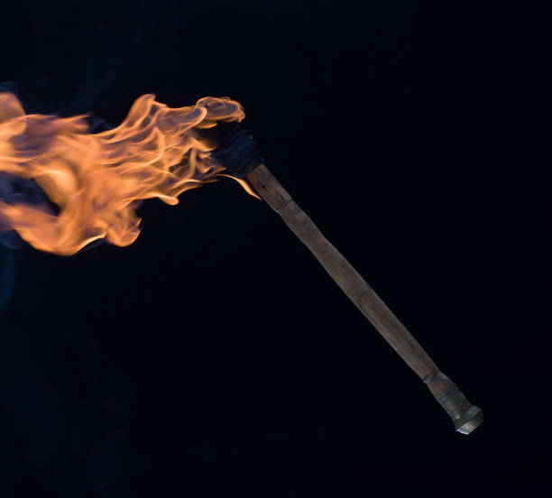 istock burning wooden torch isolated on black background 1572651397