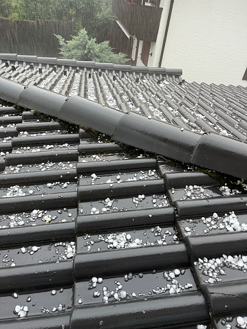 Hail on the roof. Summer storm. Hailstones the size of cherries. Large hail is lying on the roof.