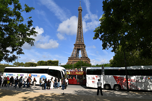 Paris, France-07 26 2023: Tour buses and tourists in front of the Eiffel tower in Paris, France.