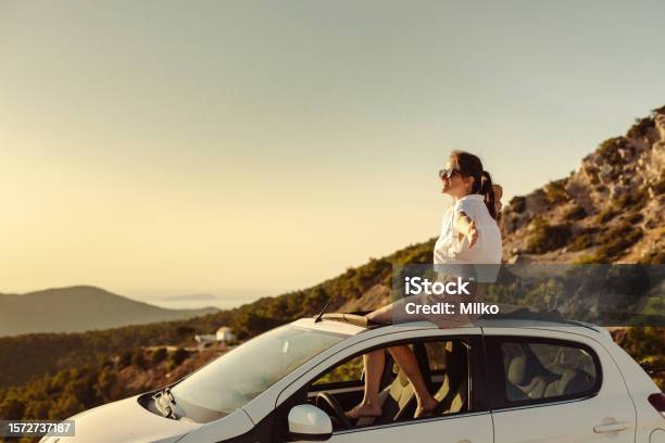 Woman Enjoying The Beautiful Sunset O Na Road Trip Stock Photo - Download Image Now - Car, Car Rental, Landscape - Scenery