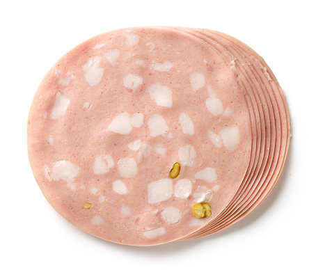 slices of pork sausage with pistachios isolated on white background, top view
