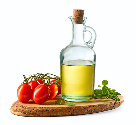 olive oil and tomatoes on wooden cutting board isolated on white