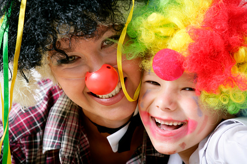 Happy mother with her son dressed as clowns.