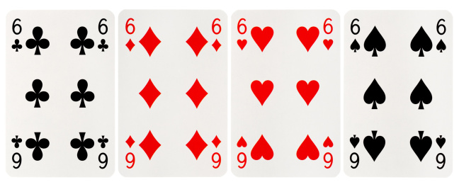 Close up of the four kings in a deck of playing cards on a black background.